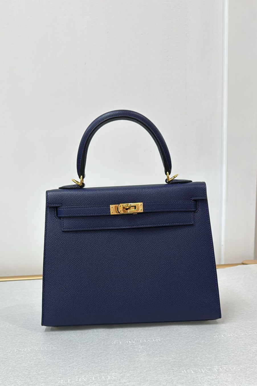 Hermes navy blue leather handbag, a perfect accessory for formal events and everyday wear.
