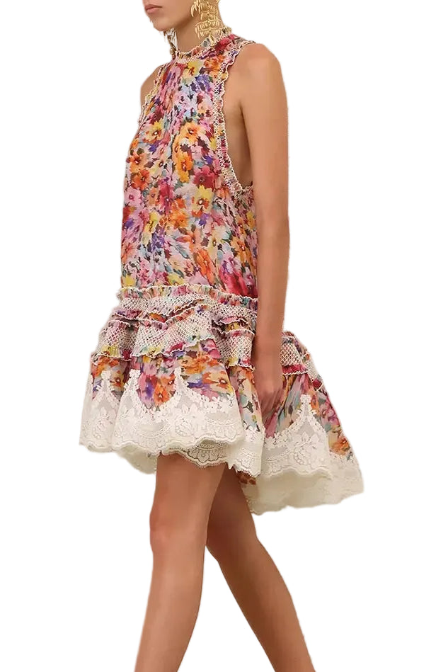 Model wearing a Zimmermann floral dress with lace trim and layered ruffles, showcasing vibrant colors and intricate design.