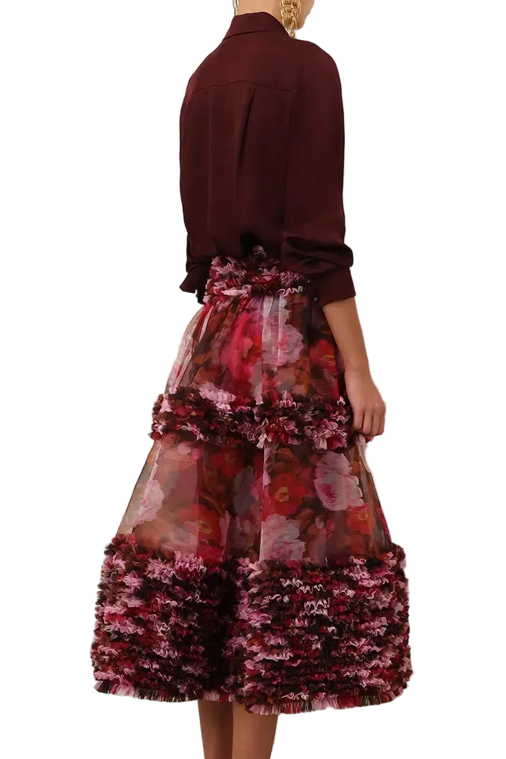 Back view of a woman wearing a Zimmermann Luna Ruffle Midi Skirt in Chocolate Rose with tiered ruffles and textured trim.